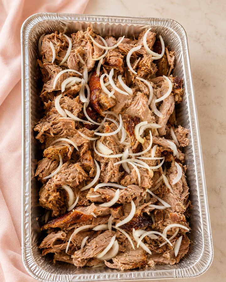Catering tray of Añejo lechón with sliced onions